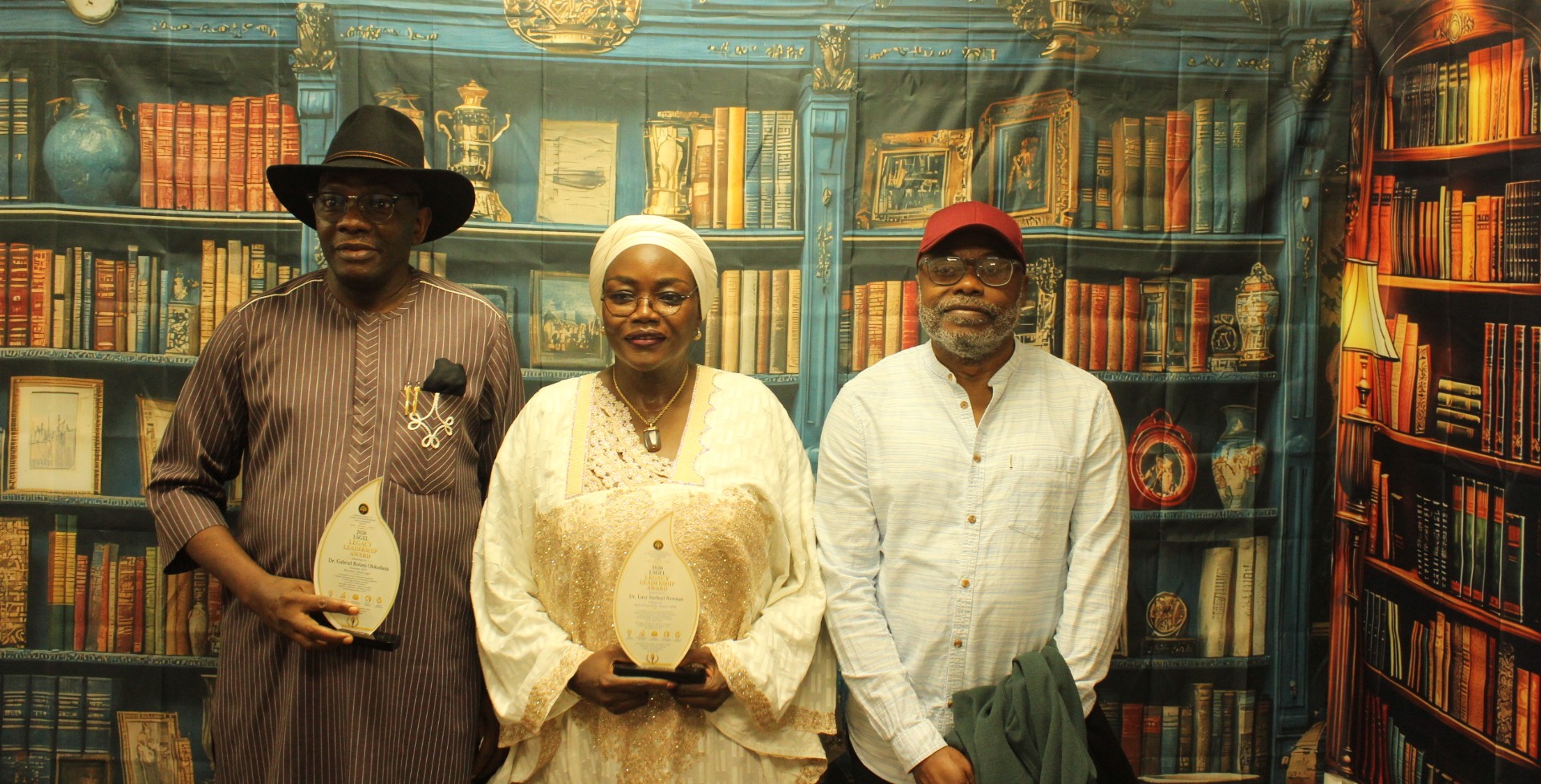 Three leaders at a 2026 leadership awards event, two holding awards